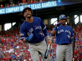 Toronto's Devon Travis (left) jogs to the dugout after scoring in the fourth inning against Texas on Oct. 6.