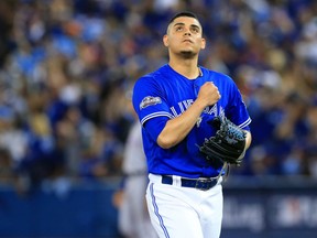 Toronto closer Roberto Osuna reacts after striking out a Texas Ranger in the 10th inning on Oct. 9.