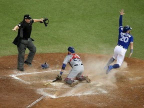 Josh Donaldson (right) turns to celebrate after scoring the winning run in Game 3 of the ALDS against the Texas Rangers on Oct. 9.