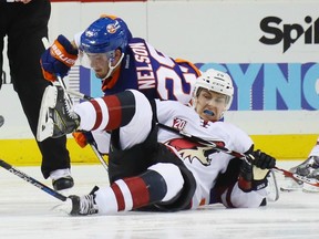 Then-Arizona Coyotes forward Dylan Strome (right) is tripped on a face-off by the New York Islanders' Brock Nelson on Oct. 21.