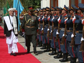In this Sept. 29, 2016, photo, Afghan President Ashraf Ghani, left, inspects an honor guard at the presidential palace in Kabul, Afghanistan.