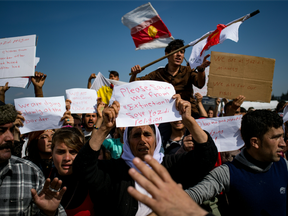 Yazidi refugees protest to call for the reopening of the borders at a makeshift camp at the Greek-Macedonian border near the village of Idomeni on March 21, 2016.