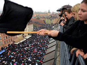 A girl waves a black flag as people take part in a nationwide strike and demonstration to protest against a legislative proposal for a total ban of abortion on October 3, 2016 in Warsaw