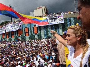 Lilian Tintori, wife of prominent jailed opposition leader Leopoldo Lopez, waves a Venezuelan national flag during a rally against the government of President Nicolas Maduro in Caracas on October 26, 2016