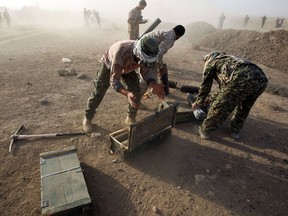Shiite fighters from the Hashed al-Shaabi (Popular Mobilisation) prepare mortars to launch on the village of Salmani, south of Mosul, on October 30, 2016 during the ongoing battle against Islamic State group jihadists to liberate the city of Mosul.