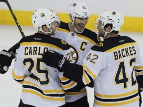 From left, Brandon Carlo, Zedno Chara and Dave Backles of the Boston Bruins celebrate a goal during Monday's  4-1 win over the Winnipeg Jets in NHL action.