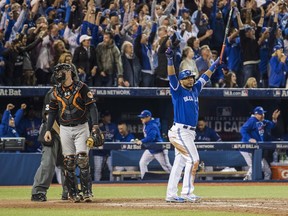 Toronto Blue Jays' Edwin Encarnacion, right, celebrates after hitting a walk-off three-run home run as Baltimore Orioles' Matt Wieters walks off the field during 11th inning American League wild-card game action in Toronto, Tuesday, Oct. 4, 2016.