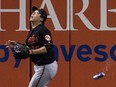 A beer can thrown by a fan sails by Baltimore Orioles left fielder Hyun Soo Kim in Toronto on Oct. 4.