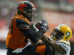 Emmanuel Arceneaux of the B.C. Lions hauls in a pass for a touchdown while being pressured by Edmonton Eskimos' Tyler Thornton during their CFL game at BC Place in Vancouver on Saturday night.