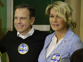 Sao Paolo mayor  Joao Doria and his wife Bia Doria, pose for photos after voting in the municipal election in Sao Paulo, Brazil, Sunday, Oct. 2.
