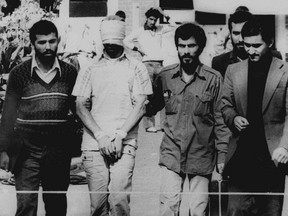 One of the hostages seized when Islamic radicals stormed the U.S. Embassy in Tehran, blindfolded and with his hands bound, is displayed to the crowd outside the U.S. Embassy in Tehran by the Iranian hostage takers on Nov. 9, 1979.