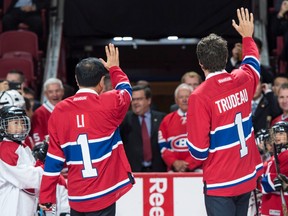 Chinese Premier Li Keqiang and Prime Minister Justin Trudeau, sporting Montreal Canadiens jerseys, wave to spectators from centre ice at the Bell centre in Montreal on Sept. 23.