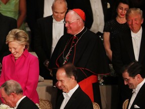 Standing between Cardinal Timothy Dolan, Hillary Clinton and Donald Trump participate in a prayer while attending the annual Alfred E. Smith Memorial Foundation Dinner in New York on Oct. 20.