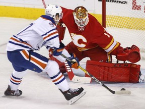 Connor McDavid of the Edmonton Oilers makes a nifty move to score against Calgary Flames' goaltender Brian Elliott during NHL acton Friday night in Calgary. McDavid had three points as the Oilers posted a 5-3 victory to sweep the home-and-home with the Flames to begin the NHL regular season.