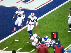 A dildo (bottom left) rests on the field near Buffalo Bills and New England Patriots players after being tossed from the stands on Oct. 30.