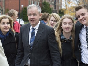 Dennis Oland and his wife Lisa, along with family members and friends, head from a bail hearing after he was released from custody in Fredericton on Tuesday, Oct. 25, 2016.