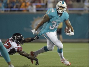 Miami Dolphins running back Arian Foster slips past Atlanta Falcons strong safety Keanu Neal during NFL preseason game in Orlando, Fla., Thursday, Aug. 25, 2016.