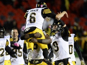 Hamilton Tiger-Cats kicker Brett Maher celebrates with teammate Jeff Mathews after making the game-winning kick against the Redblacks in overtime during CFL action on Friday night in Ottawa.