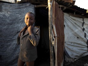 A boy stands in front of his mended home damaged by Hurricane Matthew, in Jeremie, Haiti on Monday, Oct. 10. Almost a week after Matthew's assault, power is still out, water and food are scarce, and officials say that young men in villages along the road between the hard-hit cities of Les Cayes and Jeremie are putting up blockades of rocks and broken branches to halt convoys of vehicles bringing relief supplies.