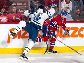 Toronto's Matt Martin (left) slams into the boards as he tries to check Montreal's Sven Andrighetto on Oct. 6.