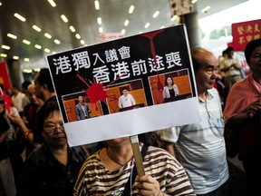 Protesters hold placards and shout slogans outside of the Legislative Council Building in Hong Kong on Wednesday.