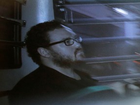 Rurik Jutting, a British banker, sitting in a prison bus arrives at a court in Hong Kong in 2014