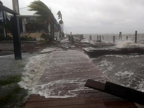 High surf from the Banana River crashes up on a dock at Sunset Grill in Cocoa Beach, Fla.