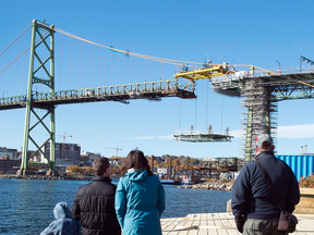 Spectators watch as workers place a new section on the Angus L. Macdonald Bridge in Halifax last year.