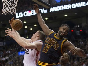 Jakob Poeltl, left, of the Toronto Raptors battles Cleveland Cavaliers' Tristan Thompson for a loose ball during NBA action Friday night at the Air Canada Centre in Toronto. The Cavaliers spoiled the home opener for the Raptors with a 94-91 victory.