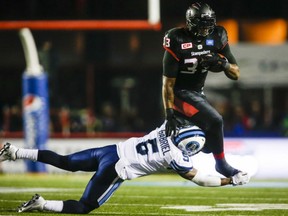 Calgary Stampeders' running back Jerome Messam tries to avoid the tackle of Toronto Argonauts' Brian Jones during CFL action Friday night at McMahon Stadium in Calgary. Messam playing a major role as the Stamps won their 14th straight game, 31-13. By improving their mark to 15-1-1, the Stamps moved to within one win of establishing a new standard of excellence in the CFL.
