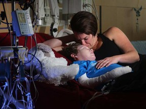 Jonathan Pitre is comforted by his mother, Tina Boileau, following a draining round of radiation in September.