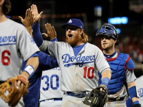 Justin Turner of the Los Angeles Dodgers is congratulated by teammates following their 4-3 win over the Washington Nationals in Game 1 of the NLDS Friday in Washington.  Turner had a homer in support of winning pitcher Clayton Kershaw.