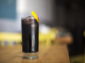 The Long Black cocktail  garnished with a citrus peel and ginger prepared at Grey Tiger in Toronto.