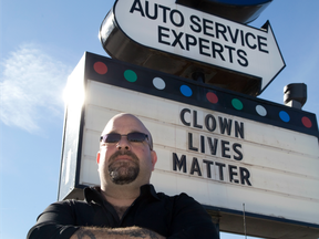 Napa Autopro superpervisor Jon Adler stands by the "clown lives matter" sign posted outside of the shop on Wellington Road in London, Ont. on Wednesday October 19, 2016.