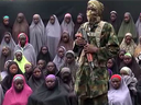 In a video screen grab created this August, a Boko Haram stands in front of some of the girls kidnapped two years ago.
