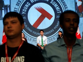 Protesters turn their backs on Prime Minister Justin Trudeau as he addresses the Canadian Labour Congress National Young Workers' Summit in Ottawa on Tuesday.