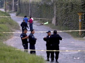 Police secure the area where six people were found alive with their hands cut off, along with another person who was killed, on the outskirts of Guadalajara, Mexico, Tuesday, Oct. 18, 2016.