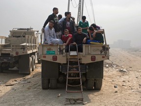 Displaced persons sit inside an army truck at a checkpoint in Qayyarah, some 50 kilometers south of Mosul, Iraq, Wednesday, Oct. 26, 2016.