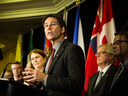 Ontario Health Minister Eric Hoskins speaks as Federal Health Minister Jane Philpott, left, listens during a health ministers' meeting in Toronto on Tuesday, Oct. 18, 2016.