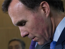 Minister of Finance Bill Morneau listens to a question during a news conference with Chairman of the Advisory Council Dominic Barton in Ottawa on Oct. 20.