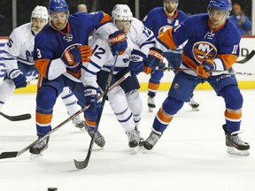 Connor Brown of the Toronto Maple Leafs is sandwiched between New York Islanders defenders Travis Hamonic, left, and Shane Prince during NHL action Sunday in Brooklyn, N.Y. The Islanders were 5-1 winners.