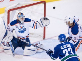 Goaltender Cam Talbot of the Edmonton Oilers knocks down a shot off the stick of Vancouver Canucks' Henrik Sedin during NHL action Friday night in Vancouver. Talbot recorded the shutout as the Oilers improved to 7-1 with a 2-0 victory.