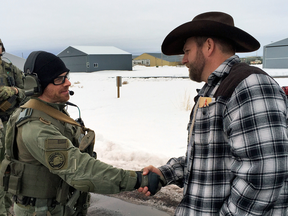 Ammon Bundy, right, shakes hand with a federal agent guarding the Burns Municipal Airport in Burns, Oregon, Jan. 22, 2016.