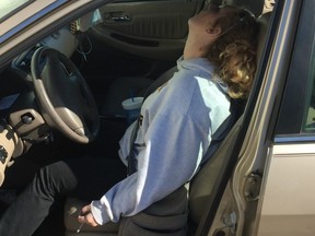 Erika Hurt sits with her baby in the back seat of the car in Hope, Ind. Police said she appeared unresponsive from an overdose and had a syringe in her hand.