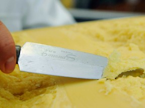 A employee cuts a piece of cheese they brand as Parmesan, at the cheese factory Algaeuland-Kaesereien GmbH in Kissleg, Germany, on Tueday, Feb. 26, 2008.