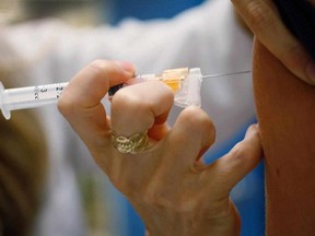 A doctor gives an HPV vaccination to a 13-year-old girl in her office in this file photo