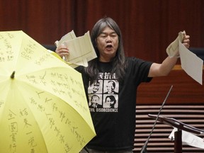 Newly elected pro-democracy lawmaker Leung Kwok-hung tears a mock copy of controversial, proposed anti-subversion legislation as he takes oath in the new legislature Council in Hong Kong, Wednesday, Oct. 12, 2016
