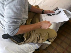 An RCMP member helps log escort advertising information into a spreadsheet format while waiting in a northeast Calgary, Alta., hotel on Oct. 13, 2016.