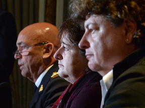 RCMP commissioner Bob Paulson answers a question during a news conference, as plaintiffs Janet Merlo, centre, and Linda Davidson listen, in Ottawa Thursday, Oct. 6, 2016.
