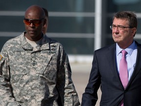 A 2015 photo shows Ashton Carter, right, accompanied by his Army Lt. Gen. Ron Lewis